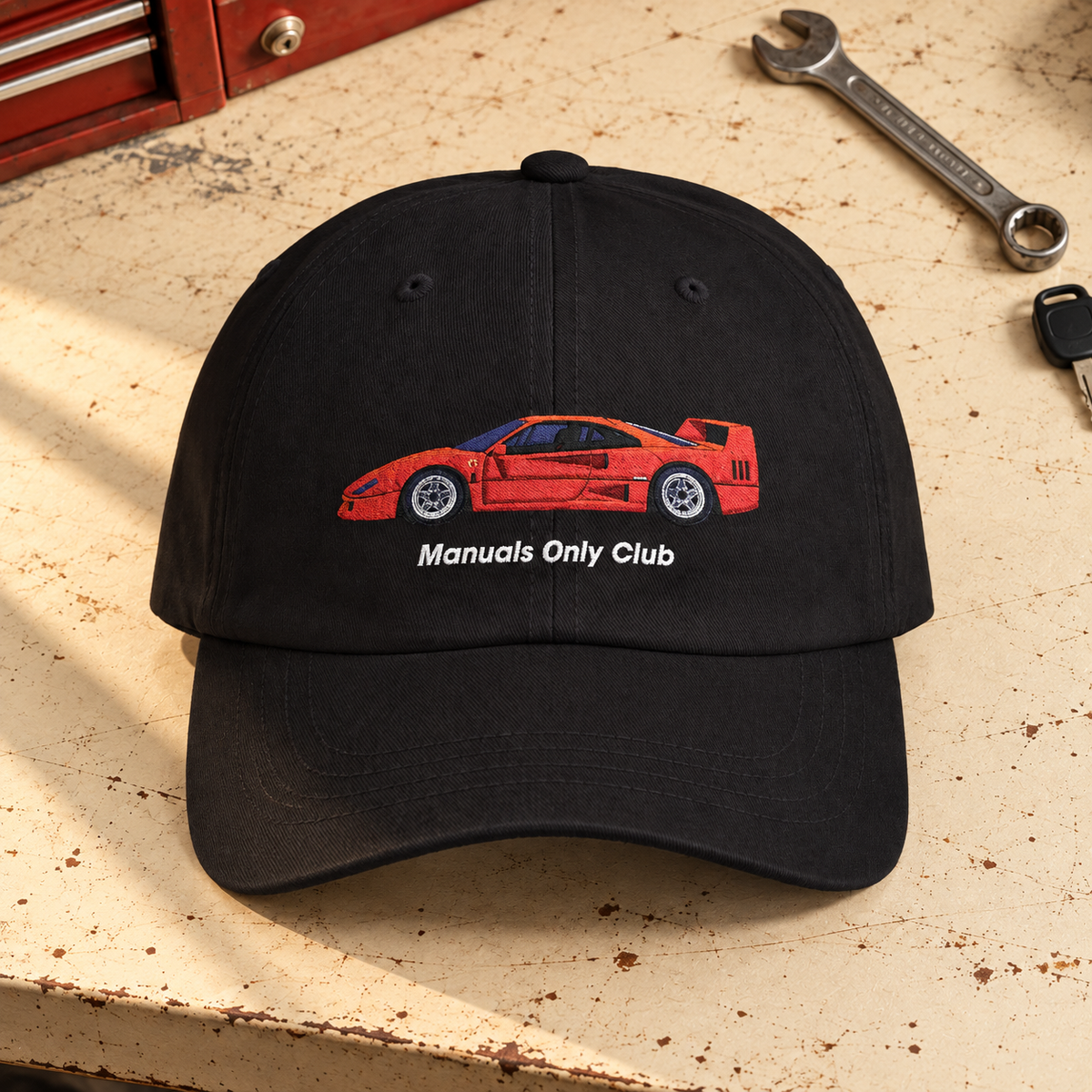 Styled mockup of the Black Retro Hat with red car embroidery on a garage workbench